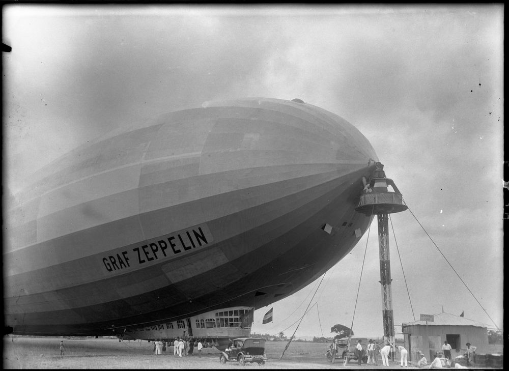 Die historische Aufnahme zeigt einen Zeppelin, der an einem Ankermast befestigt ist.