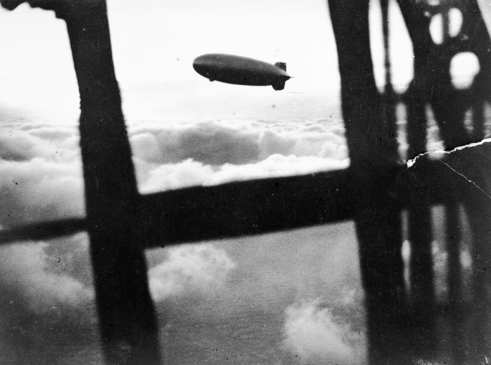 Die historische Aufnahme zeigt die Begegnung zweier Zeppeline. Das Foto entstand aus einem Gondelfenster heraus und zeigt in der Ferne einen anderen Zeppelin über Wolken.