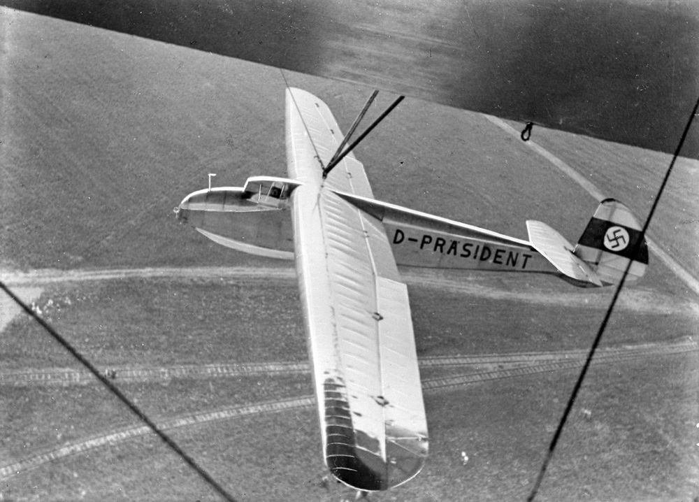 Historische Fotoaufnahme des Flugzeuges D-Präsident, welches außen an einem Luftschiff befestigt istt.