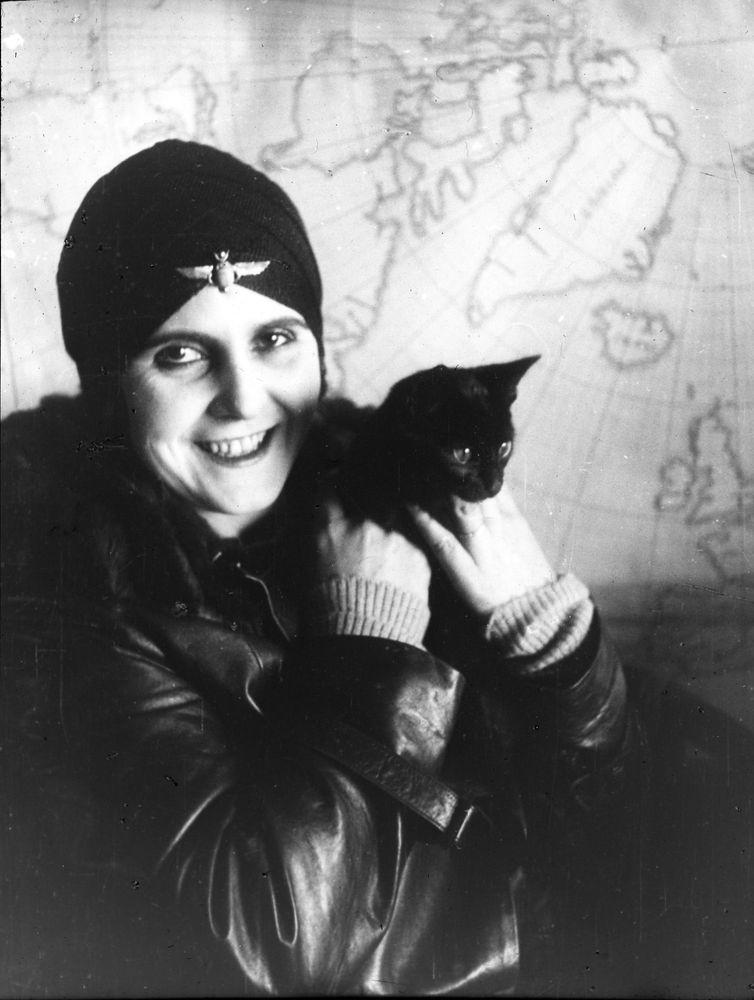 Die Aufnahme zeigt Lady Hay, die ihre kleine schwarze Katze in den Händen hält und in die Kamera lächelt.